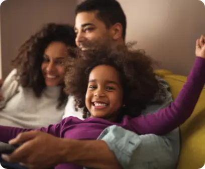 A happy family of 3 sitting on a sofa